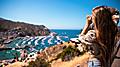 Woman on vacation taking a photo of the ocean landscape. California.