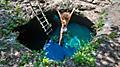 Mexico Costa Maya Woman Jumping into Cenote Azul