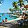 Couple having a drink while sitting under the umbrella by the pool side