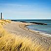 A beach in Skagen, Denmark with the Skagen Lighthouse in the distance