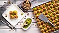 Turkish desert baklava with peanut,  pistachio, hand on fork and Turkish tea 